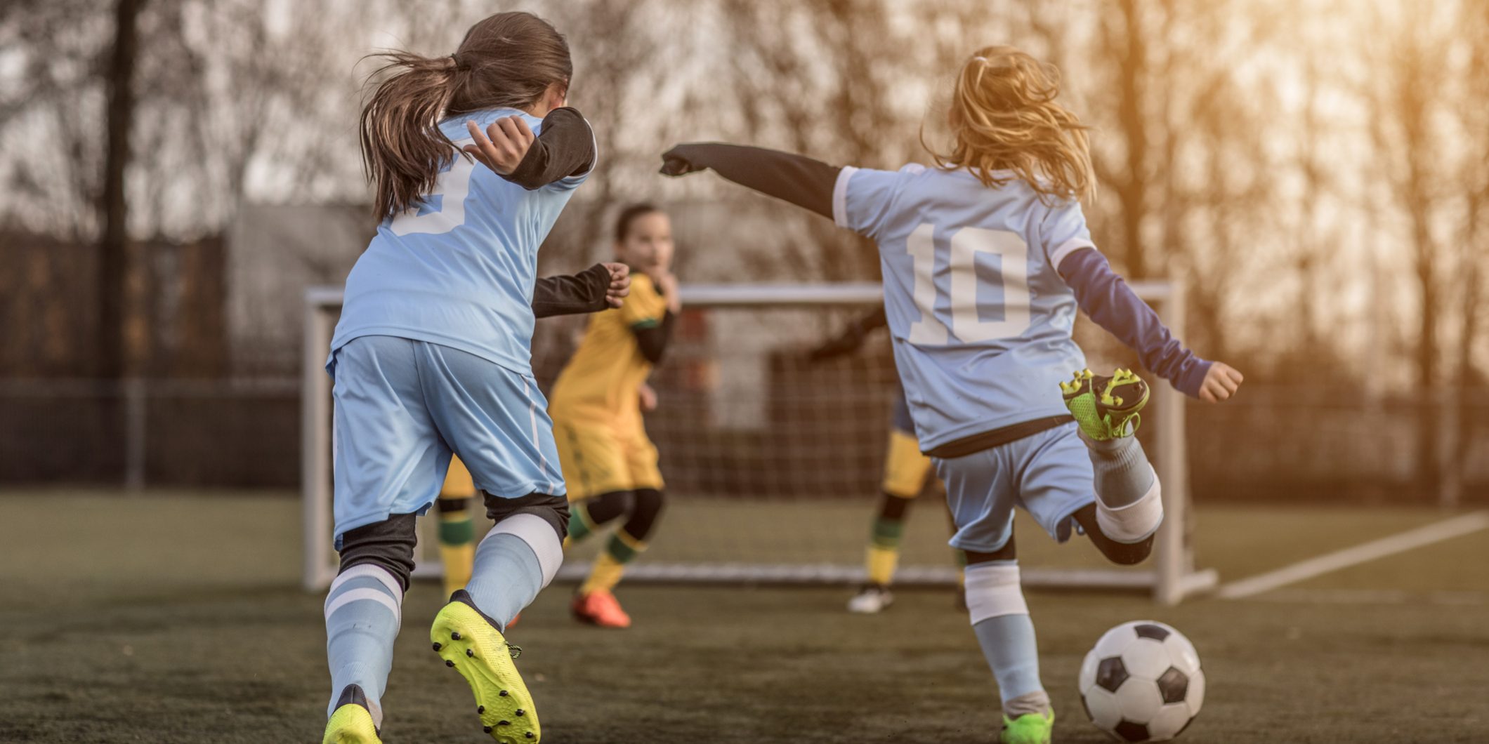 Two Female Girl Soccer Teams playing a football training match in the Spring outdoors